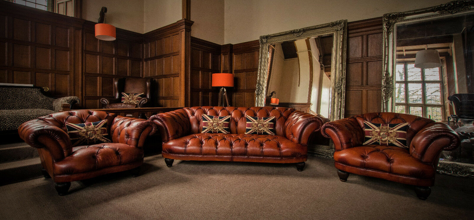 Antique tan leather Chesterfield suite in a wood-panelled hall